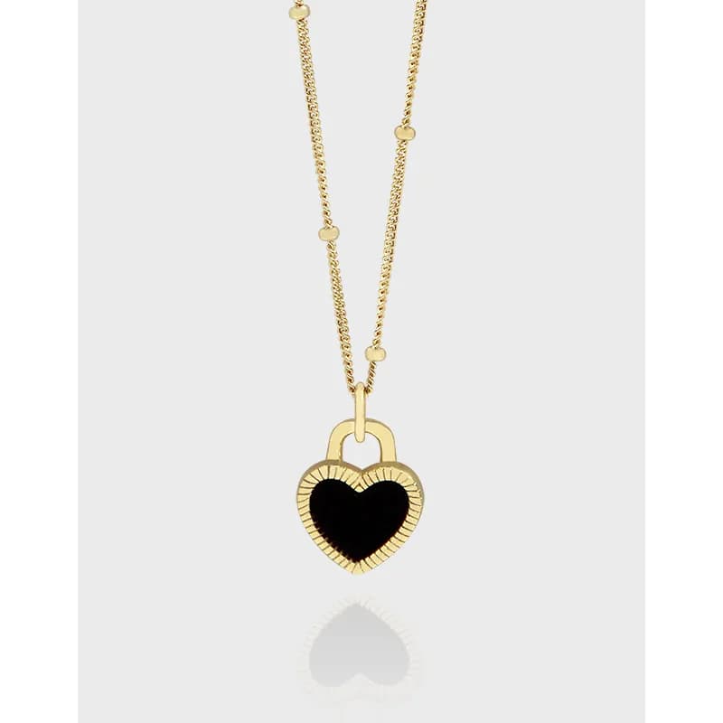 Polished sterling silver necklace with a heart-shaped black enamel pendant and dotted chain accents.