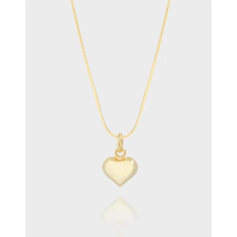Minimal sterling silver necklace with a small heart pendant hanging centered against a light background.