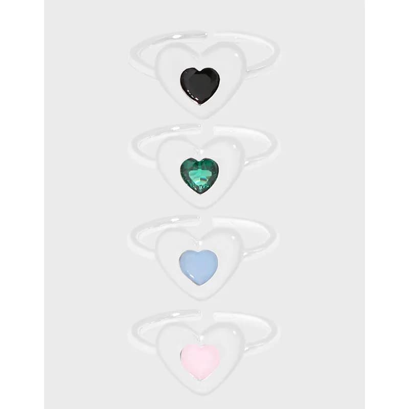 Four heart-shaped enamel rings in sterling silver, shown with colored enamel centers in black, green, blue, and pink