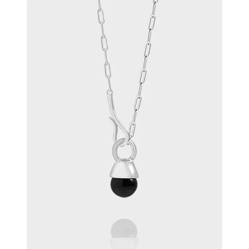 Polished sterling silver chain with a small curved connector and a black bead pendant.