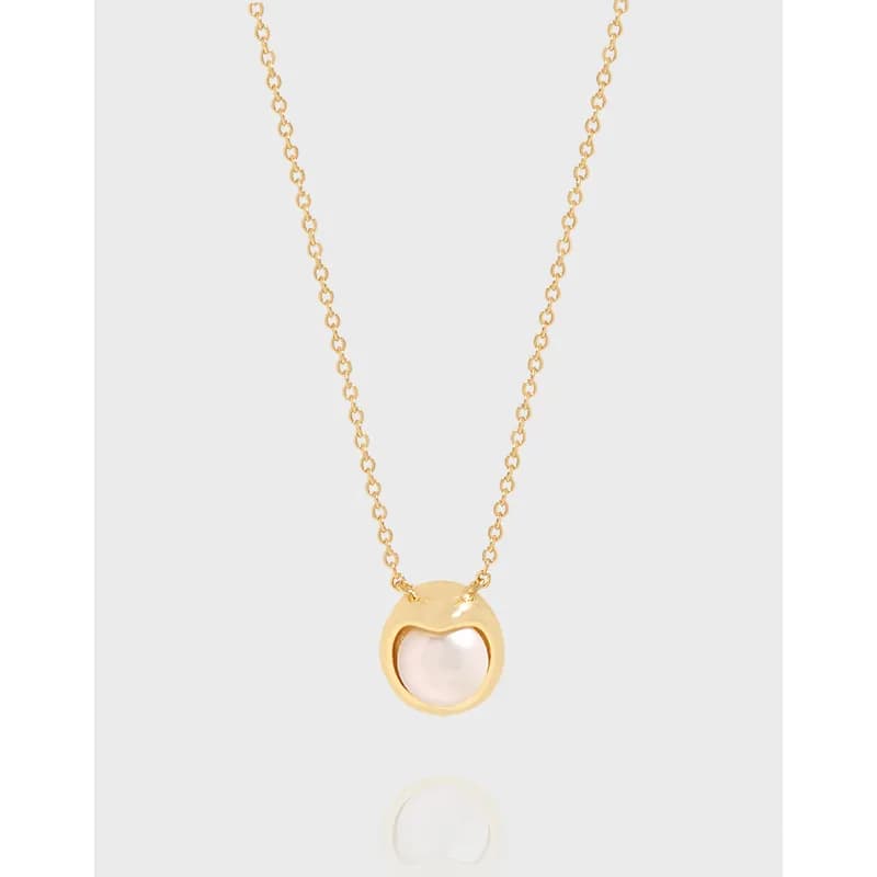 Sterling silver necklace with a circular heart-inspired pendant housing a pale pink pearl on a fine chain.