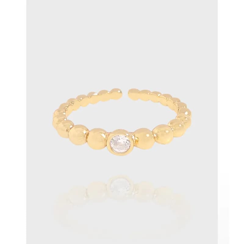 Polished sterling silver beaded ring with a central bezel-set crystal on a row of round beads.