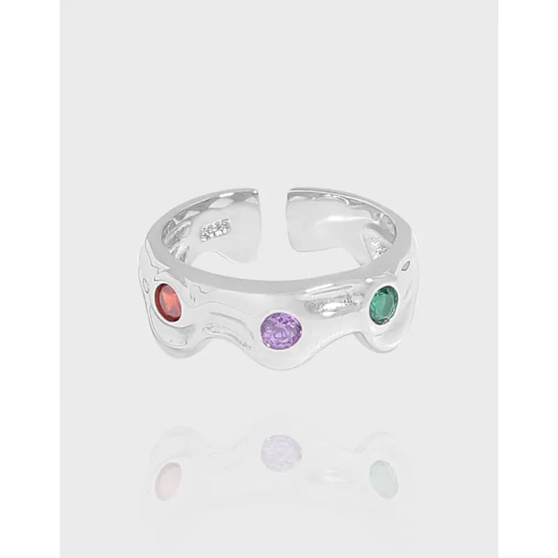 Polished sterling silver wavy ring with four colorful gemstones along the band