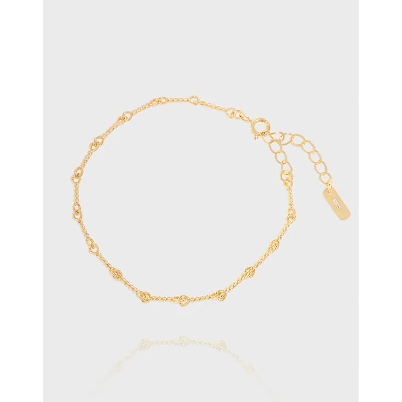 Polished sterling silver dainty link bracelet with an extender chain and small tag.