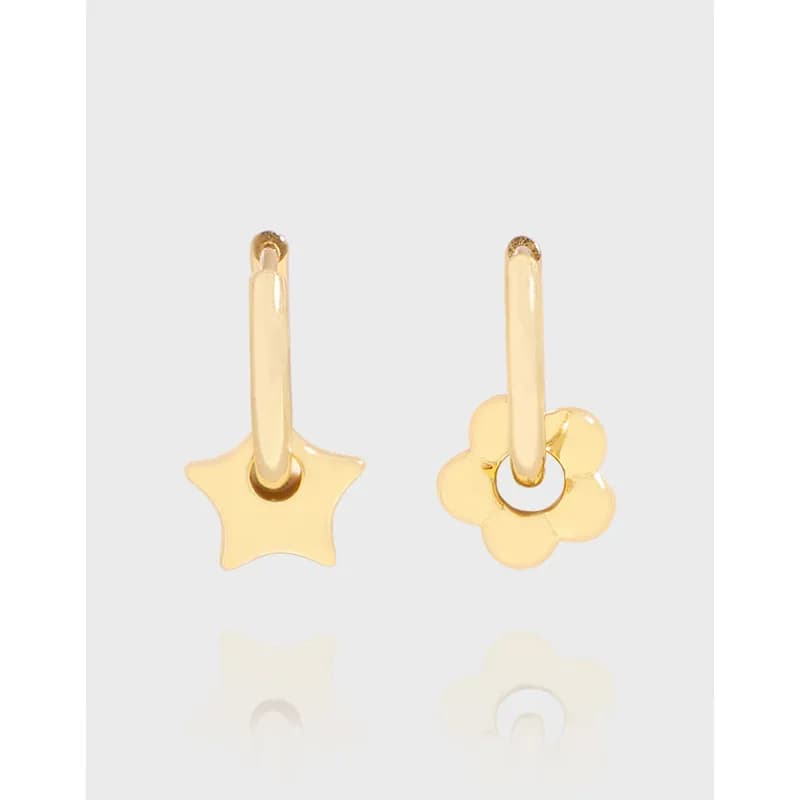 Two polished sterling silver hoop earrings each with a different charm: one star, one flower, hanging from small hoops.