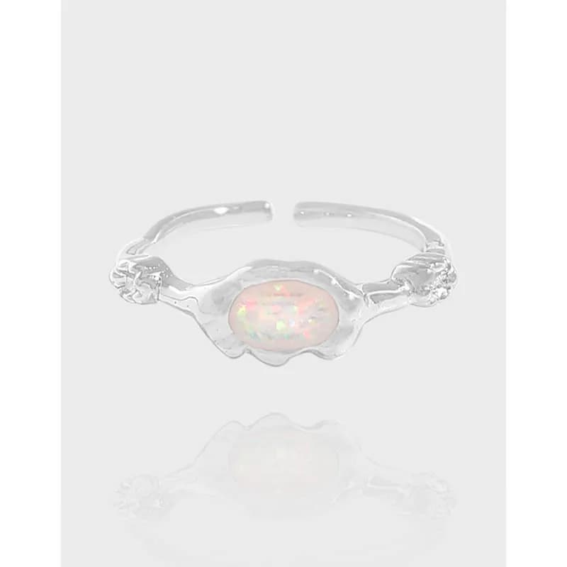 Polished sterling silver ring with an iridescent opal center in an organic bezel.