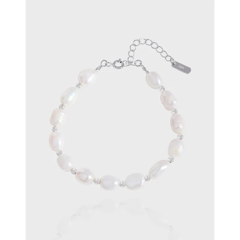Sterling silver bracelet with baroque freshwater pearls and small spacer beads on a white background.