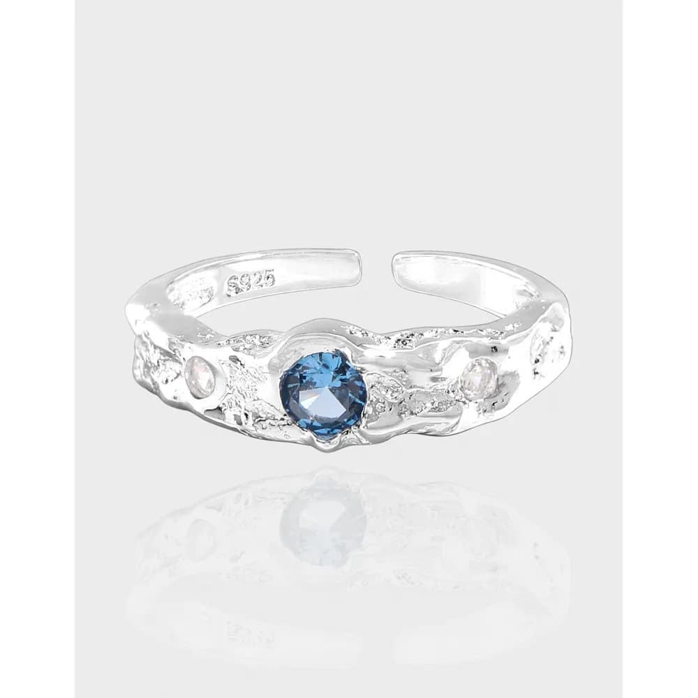 Open textured silver ring with a blue round gemstone centerpiece