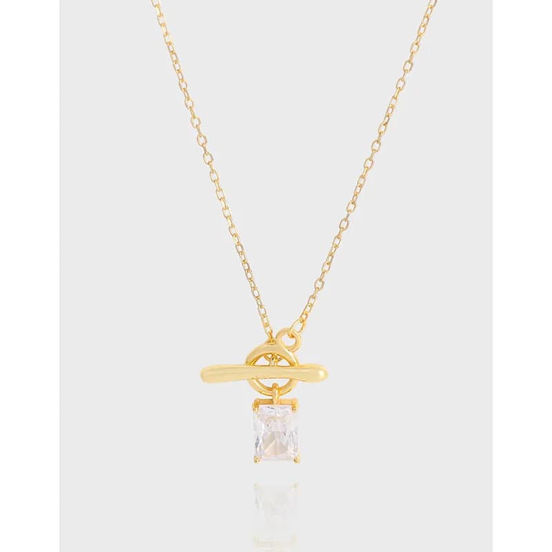 Delicate gold-tone toggle bar pendant with a square-cut crystal drop on a fine chain.