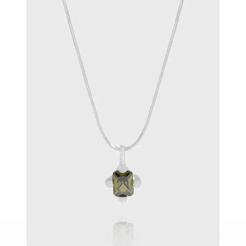 Polished sterling silver necklace with an emerald-cut olive-green gemstone pendant and small round accents.