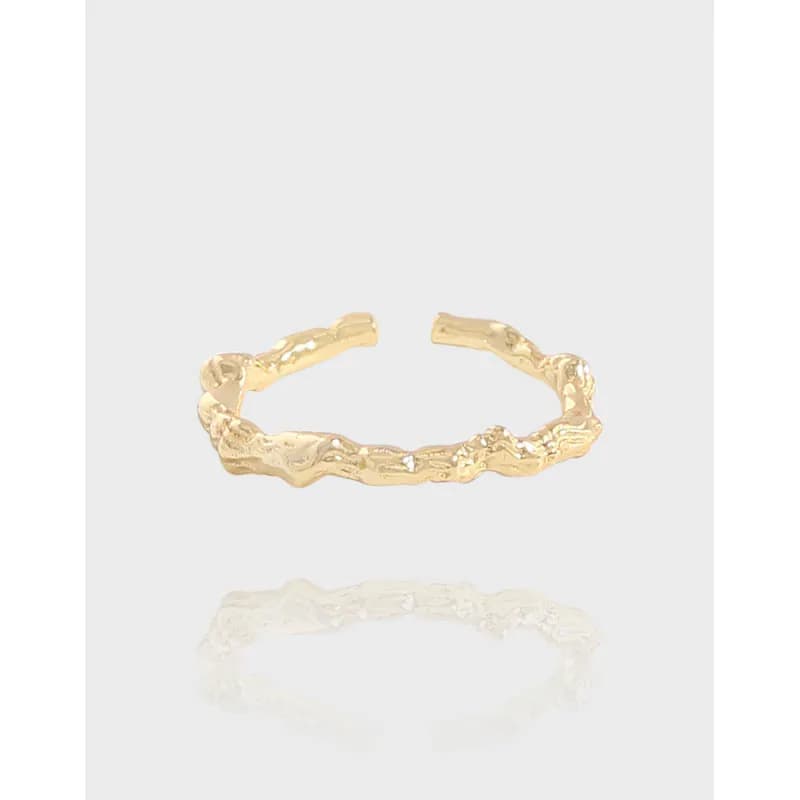 Open-ended organic texture ring in polished sterling silver with a rugged, irregular surface.