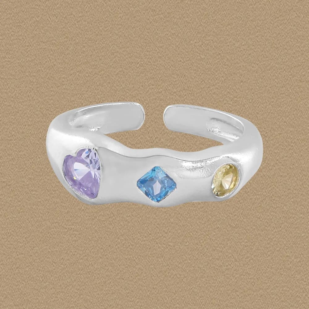 Polished sterling silver open-band ring with three colored gemstone settings along the band.