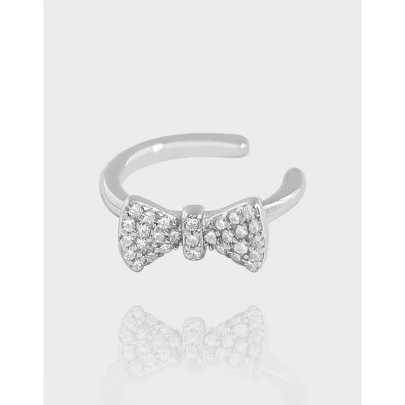 Sterling silver pavé bow earrings with a polished finish on display.