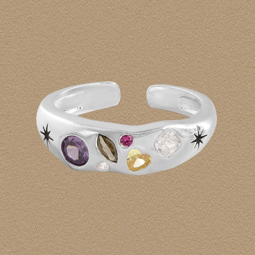 Polished sterling silver open-ended ring with a colorful gem cluster and starburst accents on the sides.