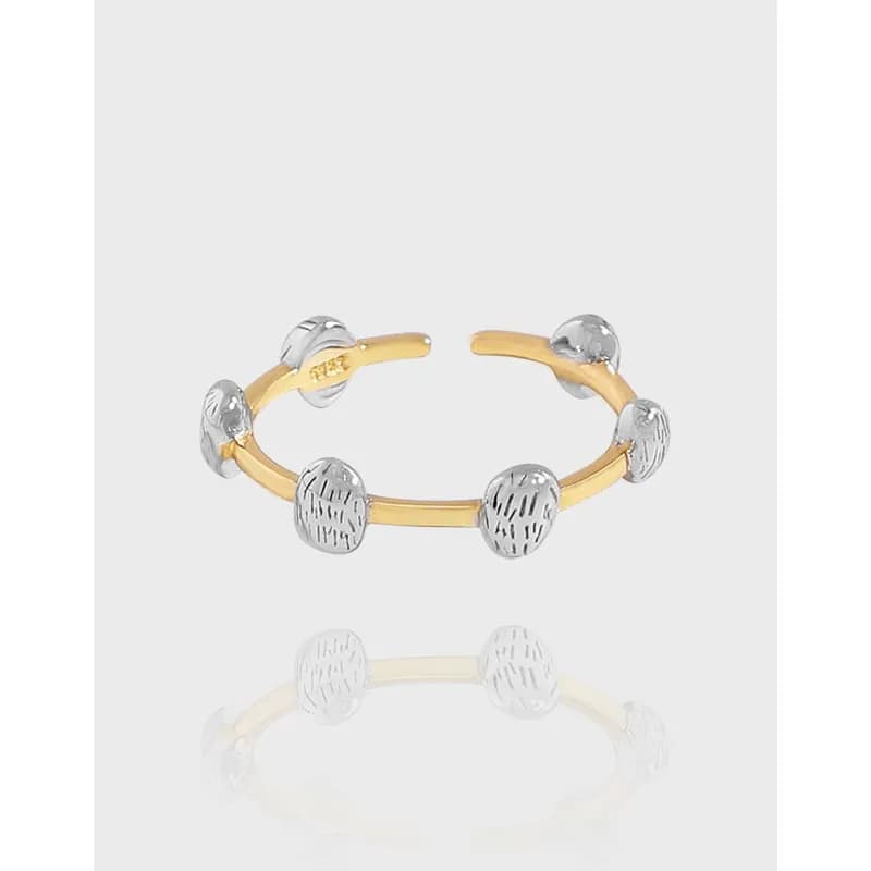 Open-ended two-tone ring with gold band and silver textured ball beads encircling it.