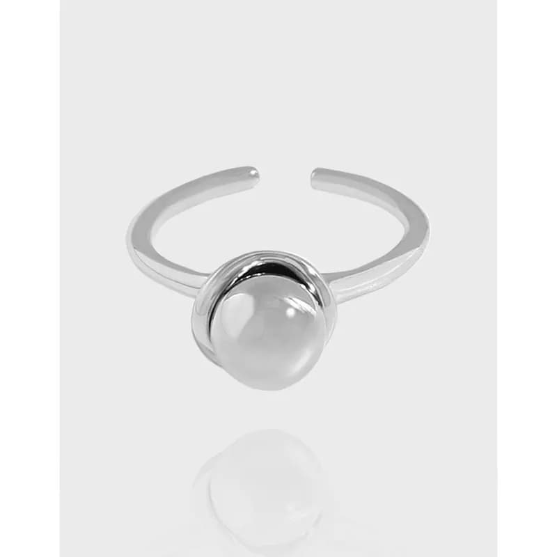 Polished sterling silver ring with a large central pearl-like bead set in curved surrounds.