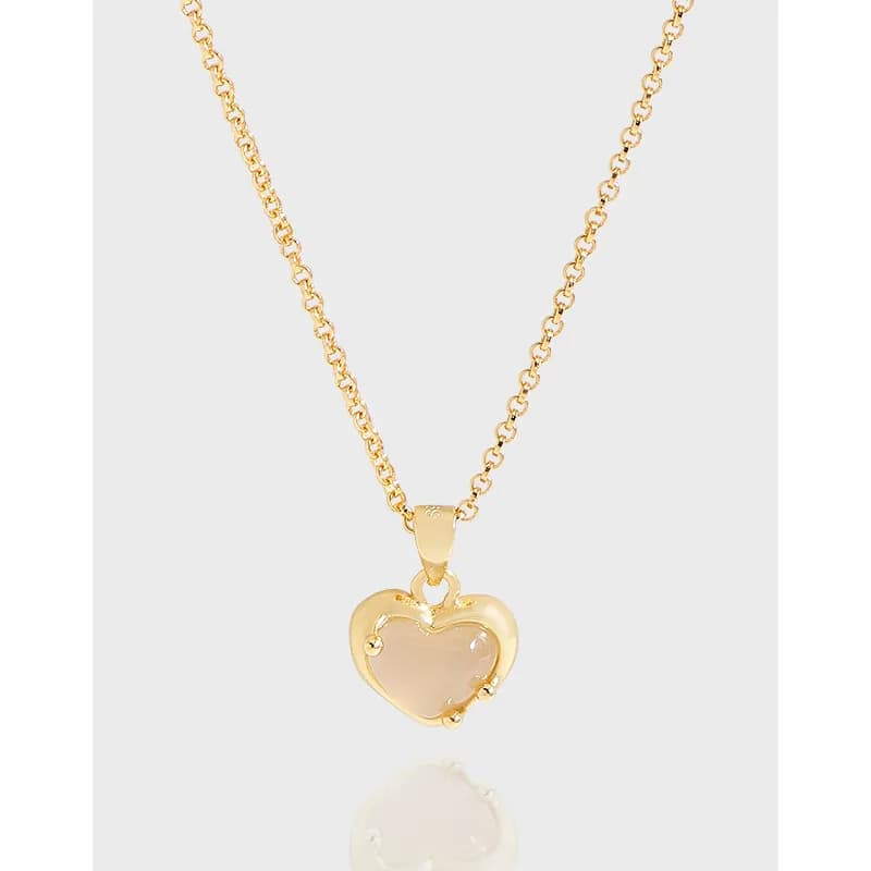 Polished gold-tone heart pendant on a delicate silver chain with a blush center stone.