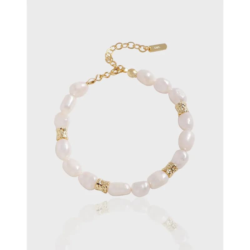 Sterling silver bracelet with pale pink freshwater pearls and gold-tone spacers on an adjustable chain.