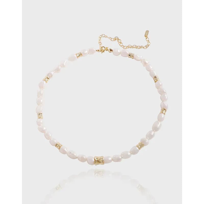 Close-up of a freshwater pearl bead necklace with gold textured spacers and a short extender chain
