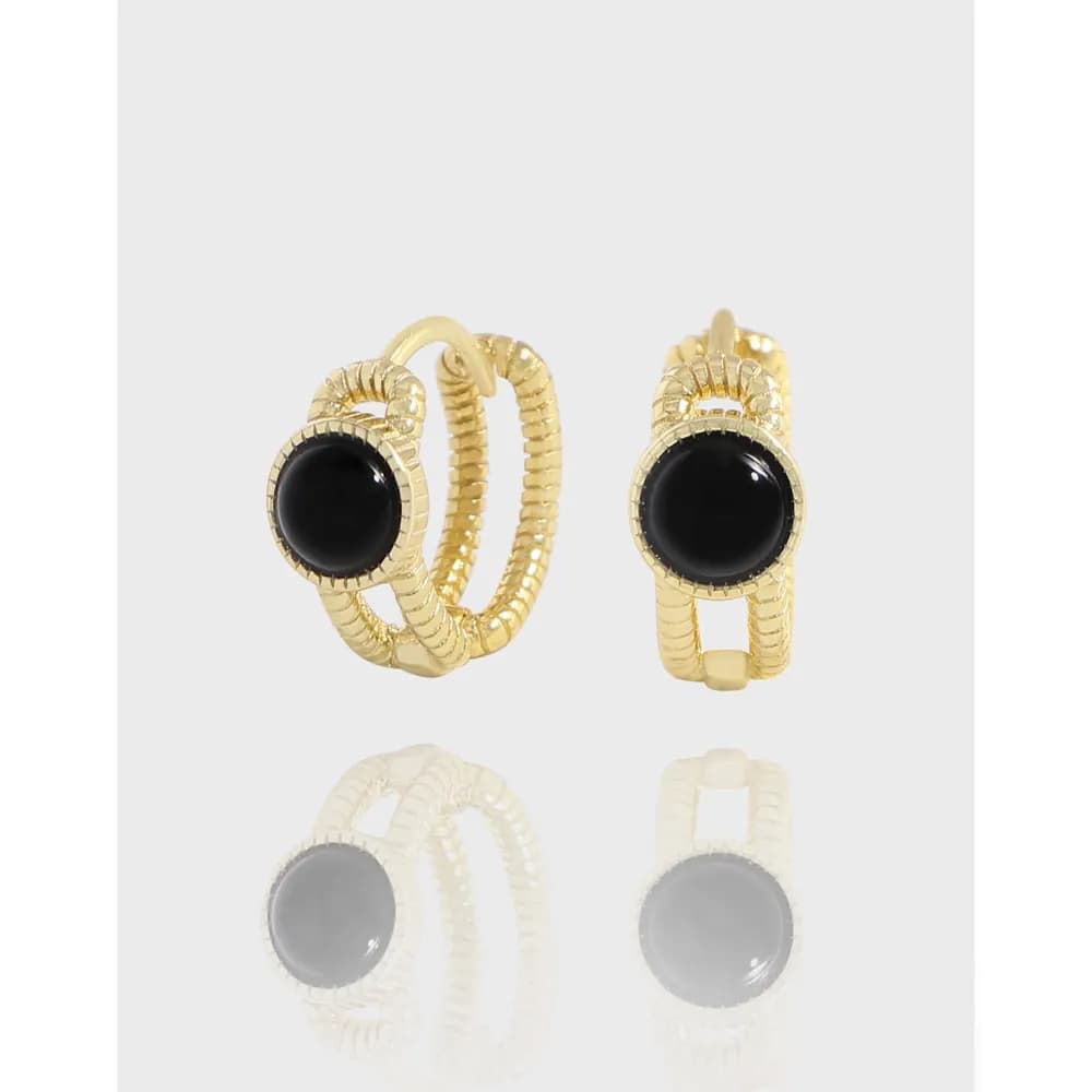 Two gold-tone hoop earrings with black round cabochons and textured, segmented detailing