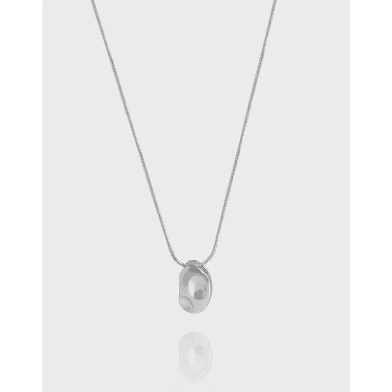 Silver necklace with a small irregular ring pendant holding a pearl-like bead