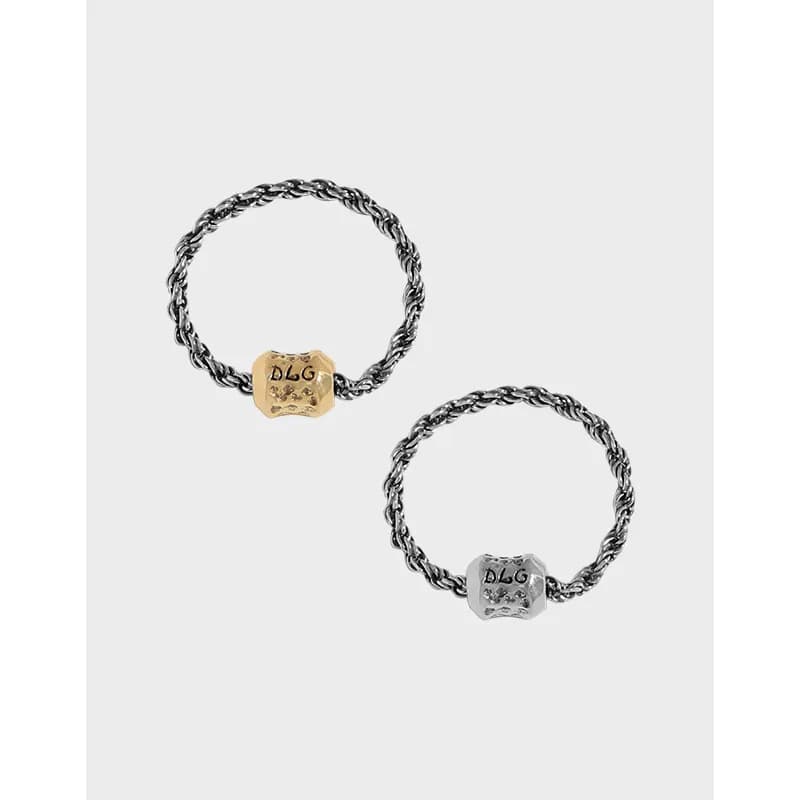 Polished sterling silver rope ring with a small square bead charm in gold or silver tone on top.