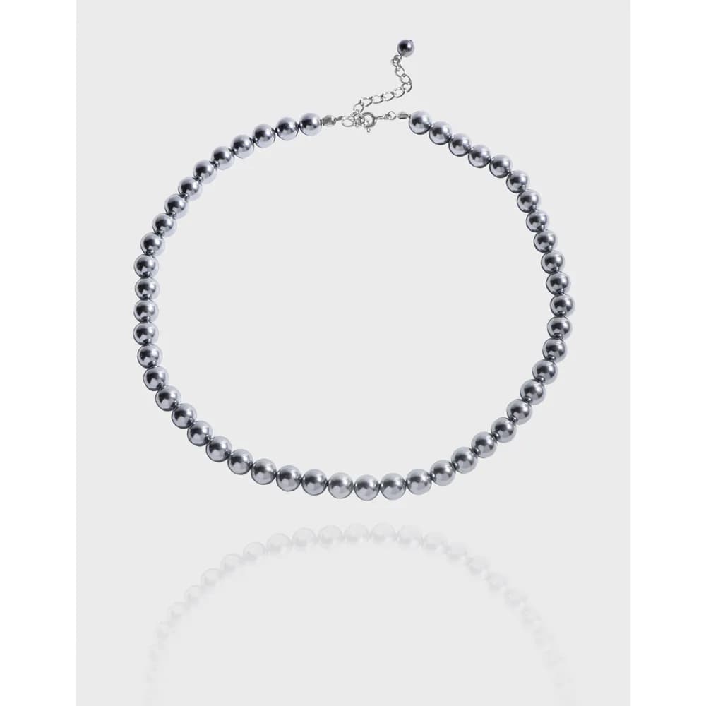 Close-up of a polished silver beaded necklace with an adjustable extender chain.