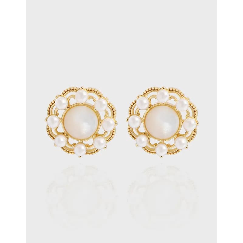 Round pearl stud earrings with a central pearl and surrounding smaller pearls in a decorative filigree setting.
