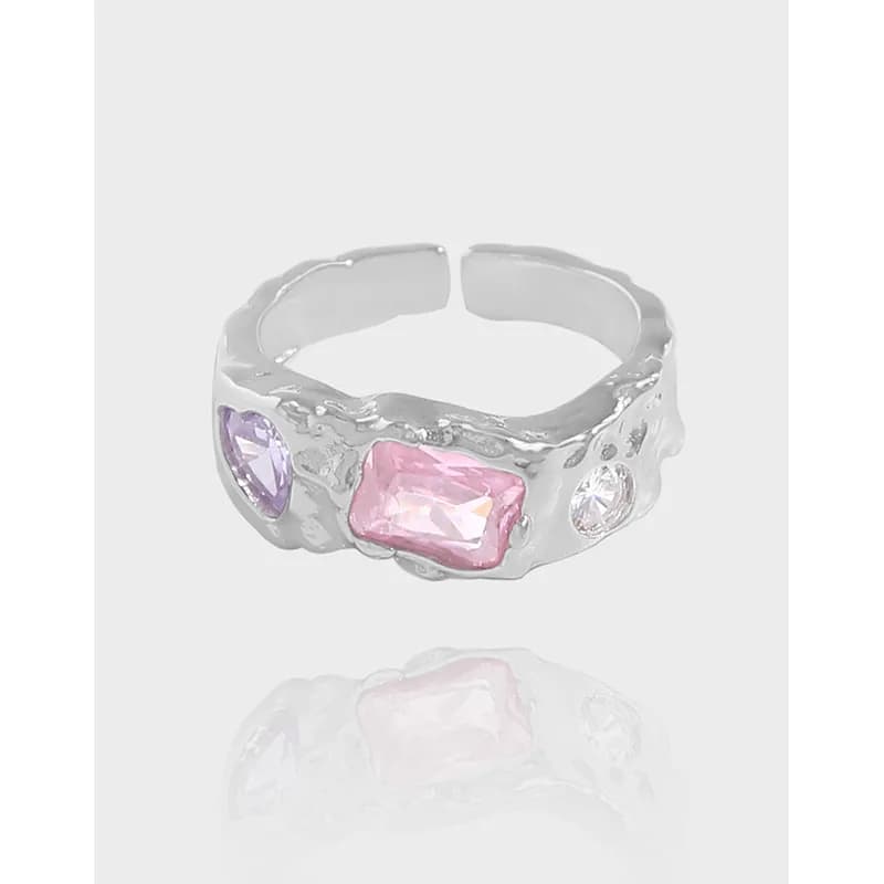 Open-back textured sterling silver ring with purple and pink rectangular stones and a small clear gem on the side.