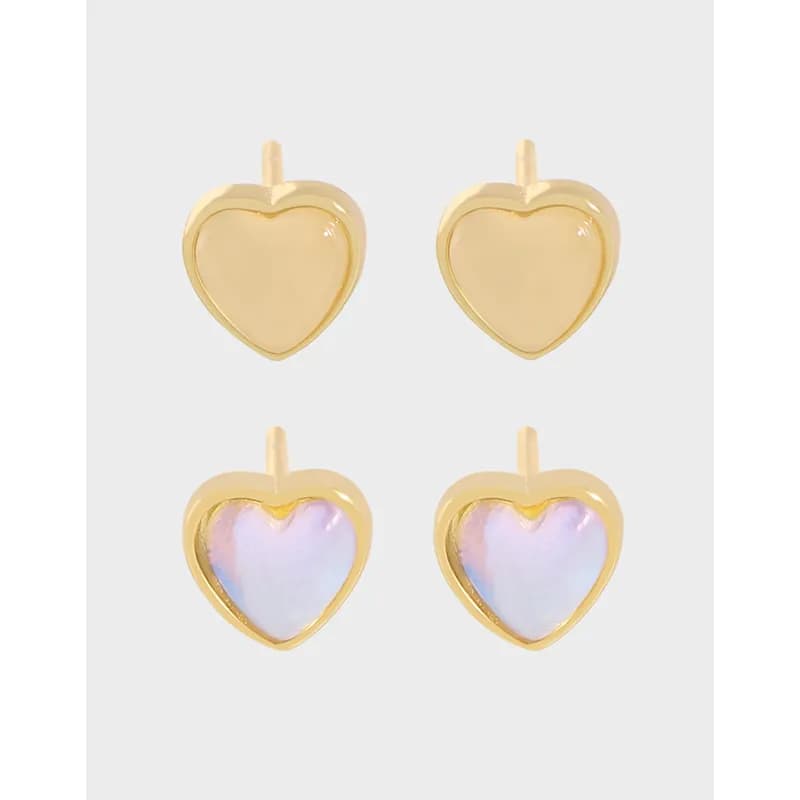 Four heart-shaped stud earrings in two styles: plain gold-toned and iridescent inlay, shown on a light background.
