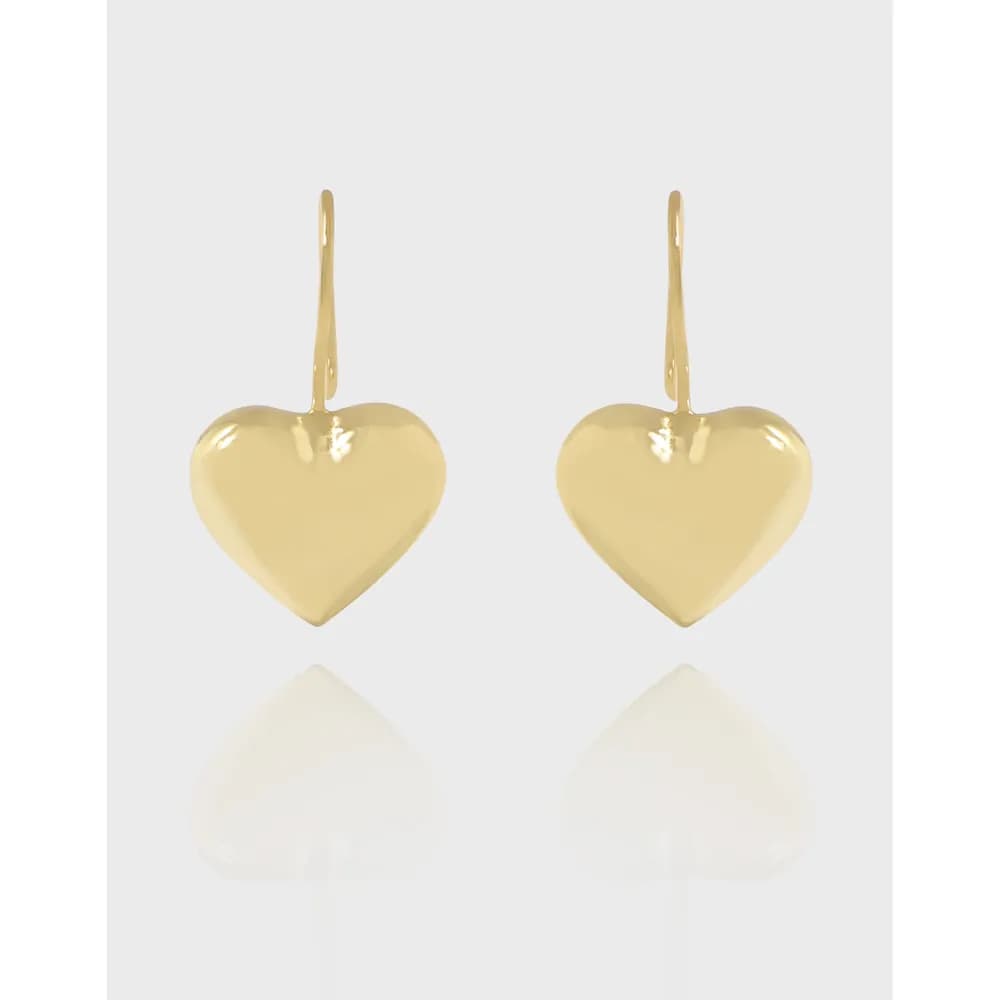 Two polished gold-tone heart-shaped earrings with hooks, shown front-facing against a light background.