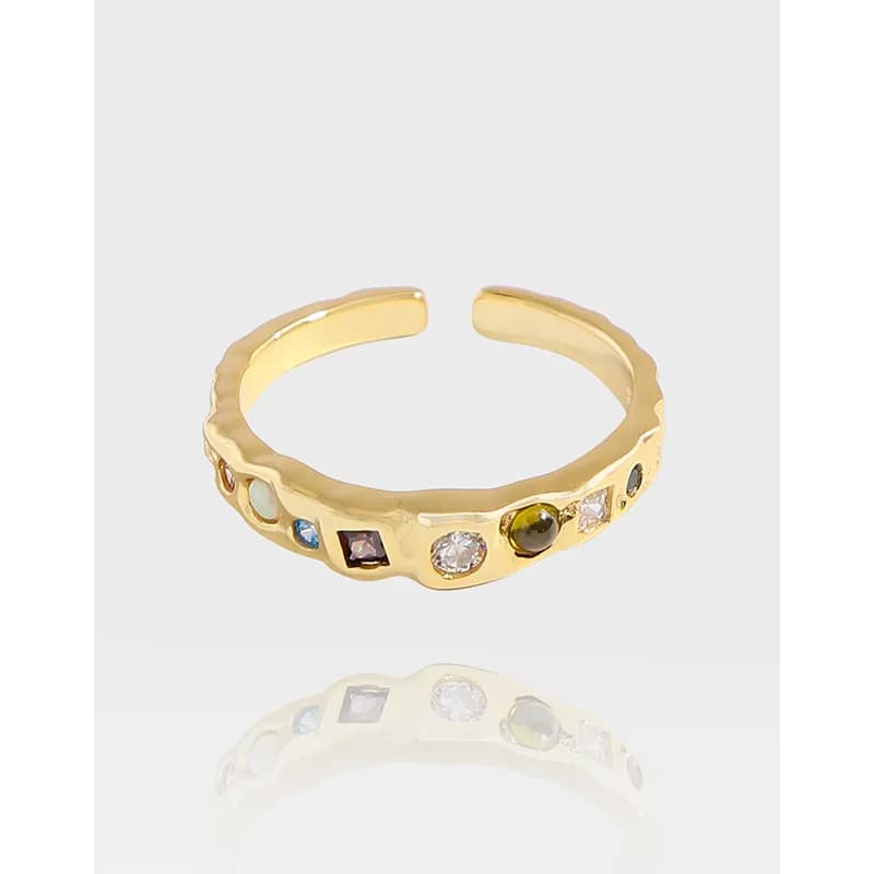 Polished sterling silver ring with a textured open band and colorful stones around the crown.