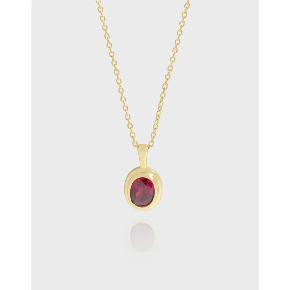 Delicate sterling silver necklace with an oval red gemstone pendant on a thin chain