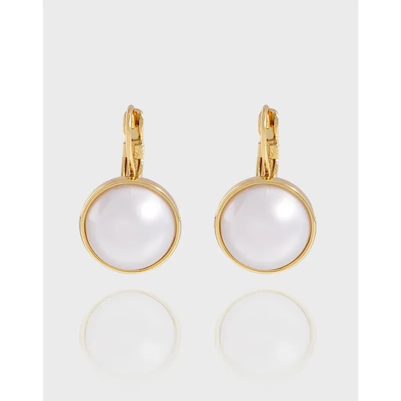 Polished pearl drop earrings with circular bezel settings and hinged backs.