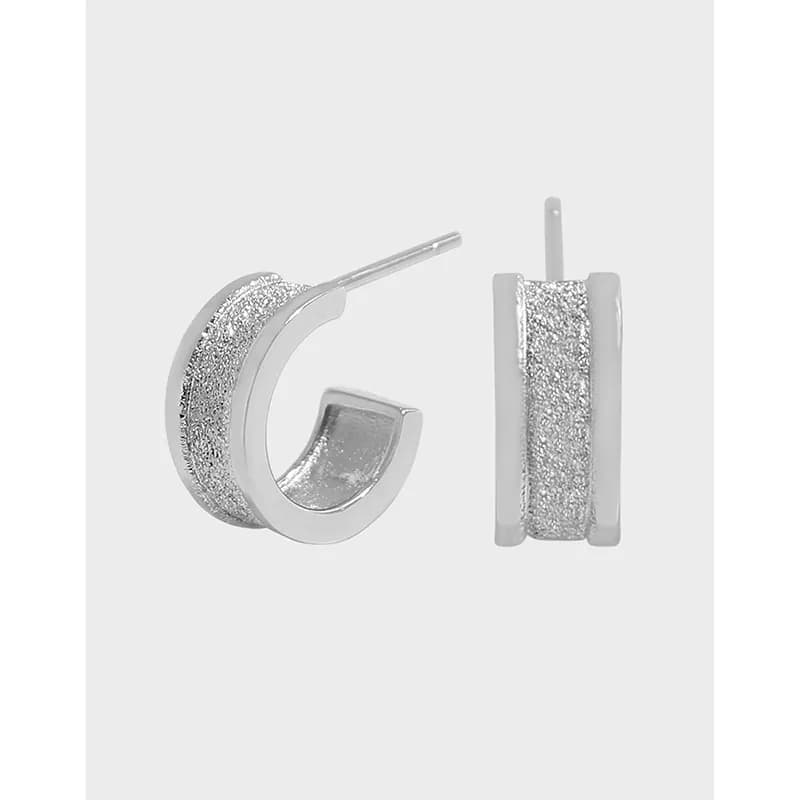 Polished sterling silver hoop earrings with a textured stripe, shown from side and front angles.