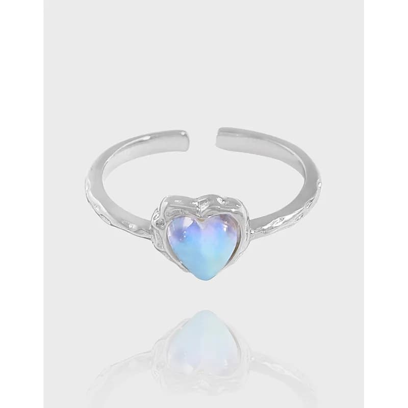 Open sterling silver ring with a heart-shaped opal centerpiece and decorative bezel