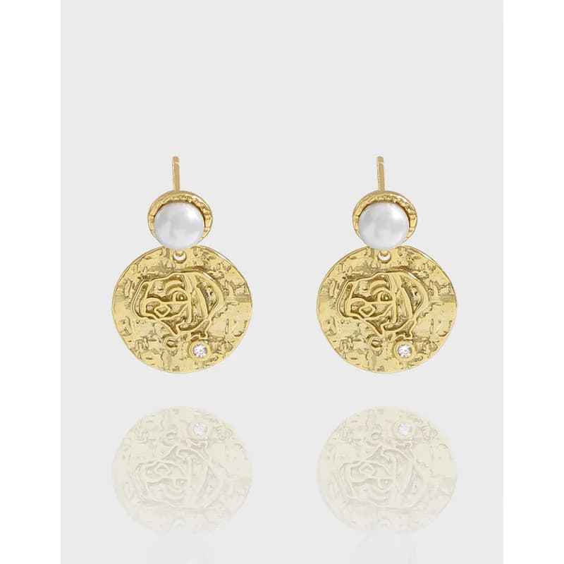 Polished sterling silver disc earrings with pearl tops and small gemstone embellishment, shown from a front view