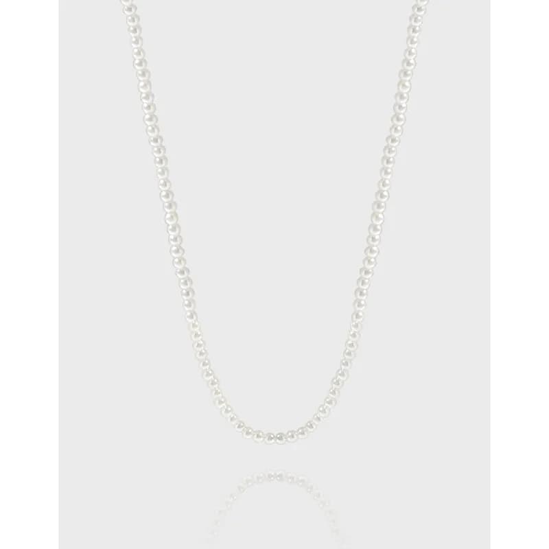 Close-up of a polished silver pearl bead necklace against a light background.