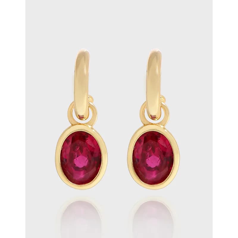 Polished sterling silver earrings with oval red stones in gold-tone bezel