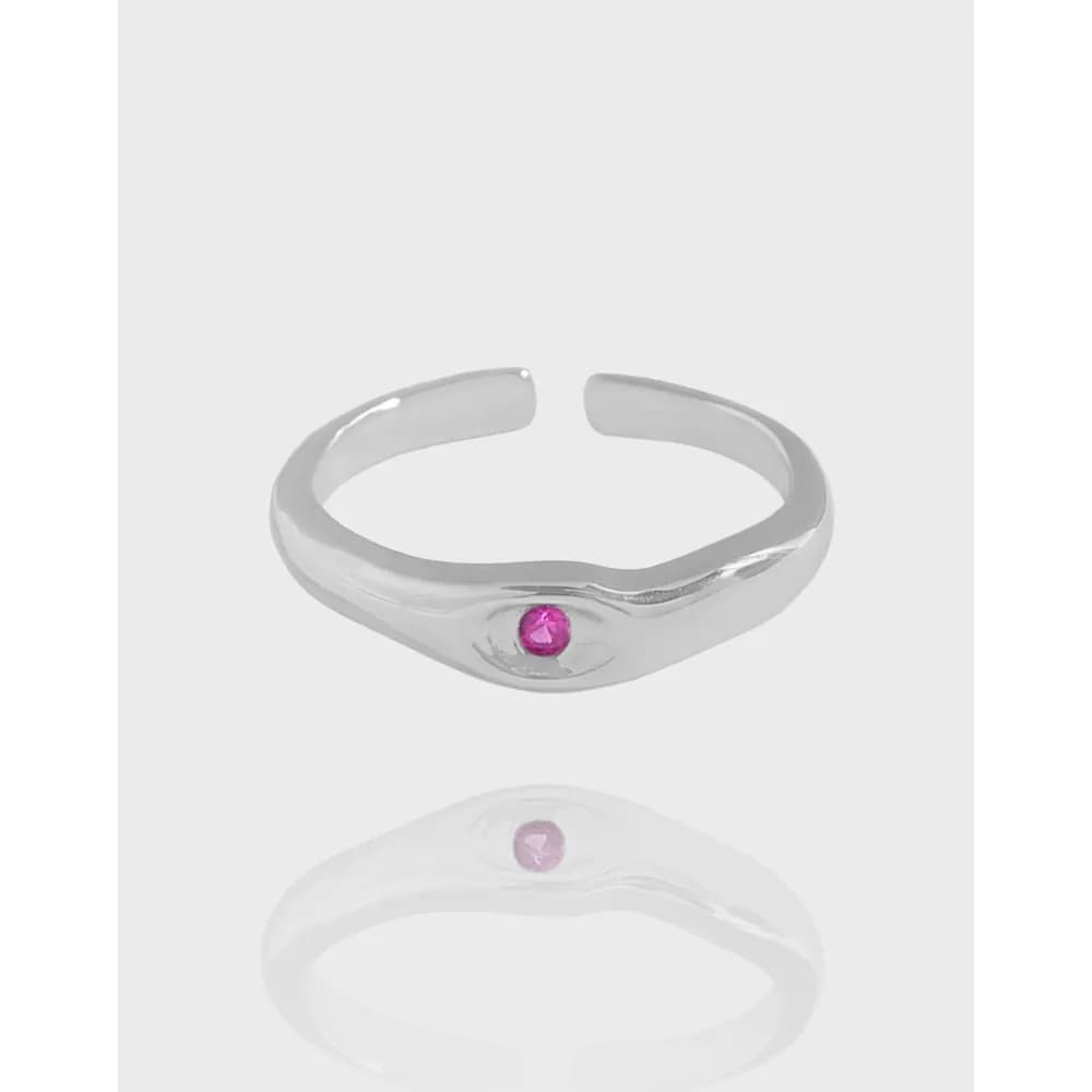Polished sterling silver ring with a small pink gemstone centered in a bezel setting.