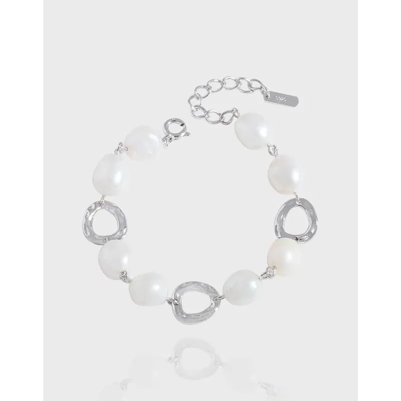 Polished sterling silver bracelet with white pearl beads and circular open-link accents, shown on a plain backdrop.