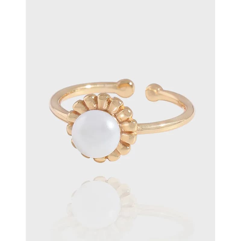 Polished sterling silver ring with a pearl-centered flower bezel and open adjustable band.