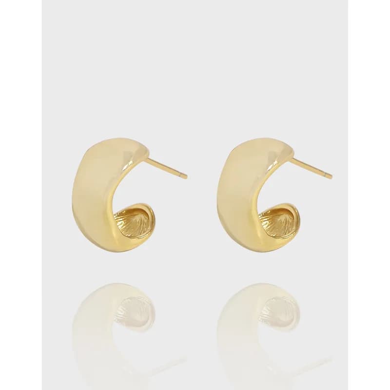 Polished sterling silver crescent hoop earrings on a light background.