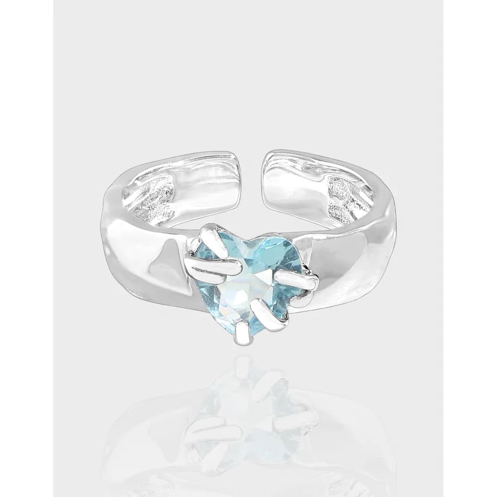 Polished sterling silver ring with a blue heart-shaped gemstone secured by prongs