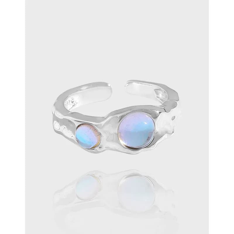 Polished sterling silver ring with two round opal cabochons set on an irregular band.
