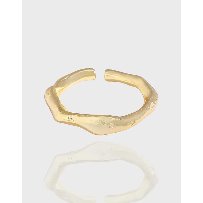 Polished sterling silver open ring with an irregular, organic texture on a light background.
