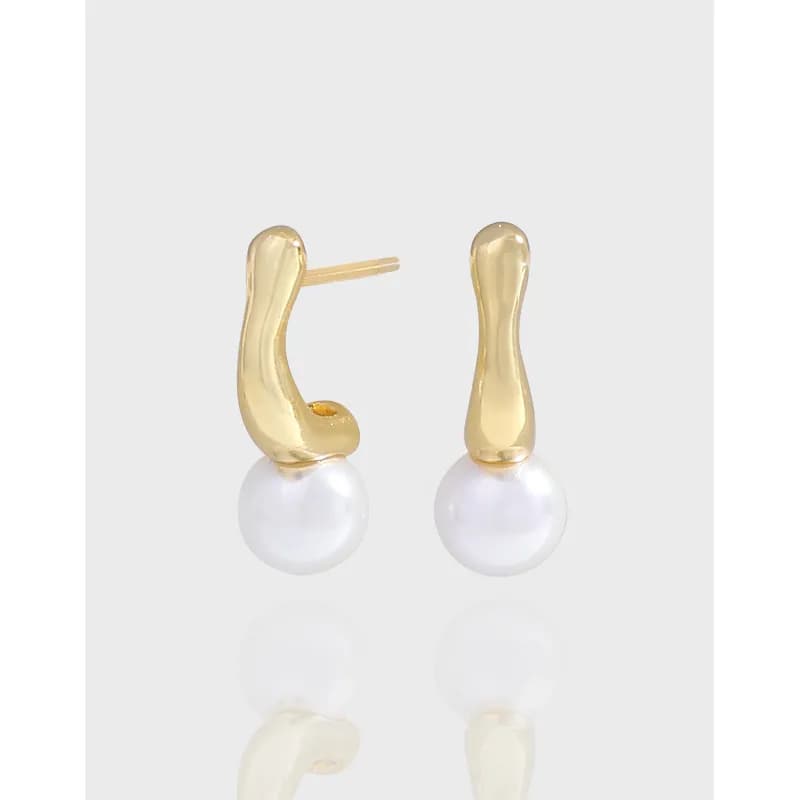 Polished pearl drop earrings with curved gold-toned stems and white pearls on a light gray background.