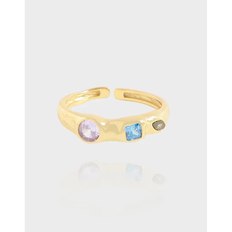 Polished sterling silver ring with three colorful stones set into the band.