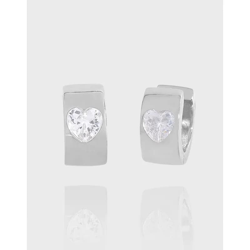 Polished silver earrings with a heart-shaped crystal inset in a rectangular block