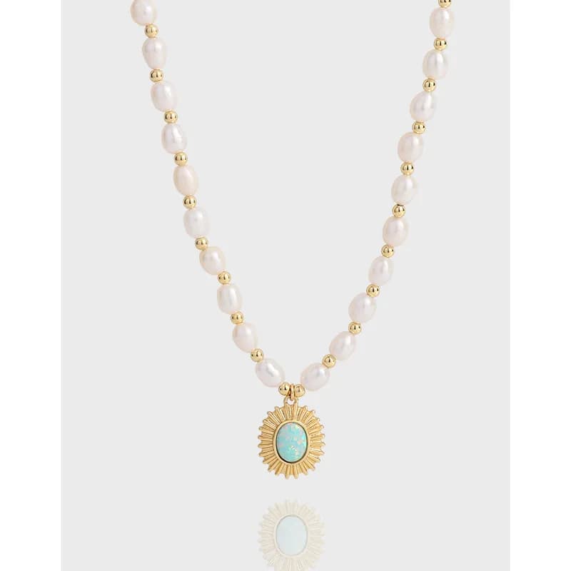 Polished sterling silver pearl necklace with a gold sunburst pendant and turquoise center
